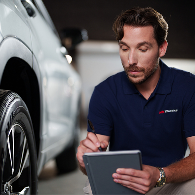 Alfa agent taking notes next to car.